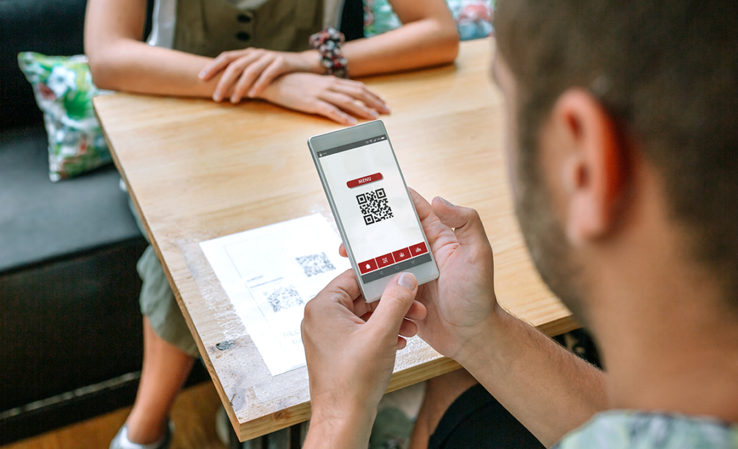 Man scanning QR code menu in a restuarant